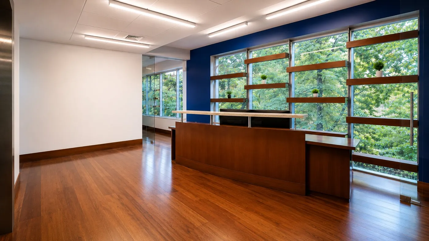 Recepción interior de la oficina con mesón en madera y vista al parque